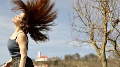 Osoba s vlajícími vlasy ve větru