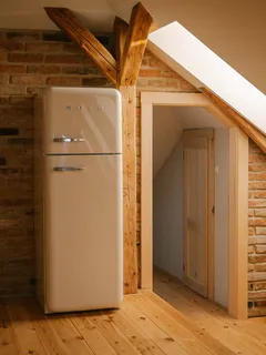 Lednice v místnosti s šikmou střechou v loftovém stylu