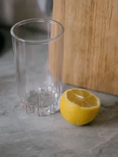 Čirý skleněný pohár s citronem na pití
