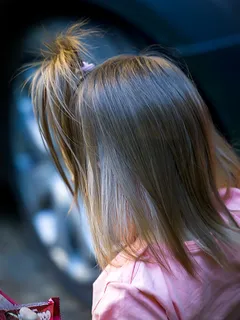 Malá dívka se dívá do dálky s zamyšleným výrazem