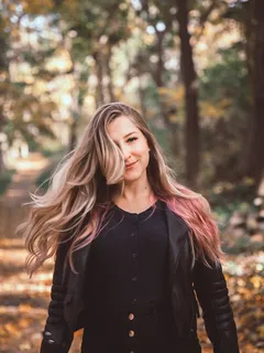 žena v černé kožené bundě v lese