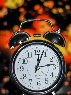 Starý bílý a černý budík ukazující 10:10