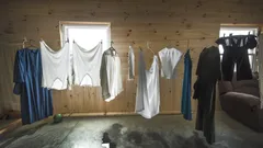 Sušící se bílé košile na dřevěné skříni v amishském domě