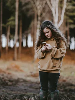 Teenagerka používá mobilní telefon v přírodě na venkově