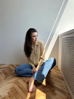 Žena sedící na podlaze se zkříženýma nohama v klidném prostředí