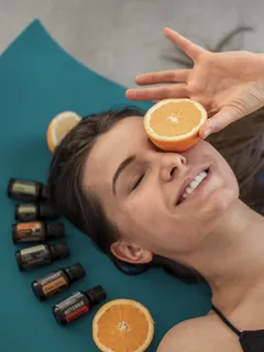 Žena na podložce s pomeranči na hlavě, relaxace s esenciálními oleji
